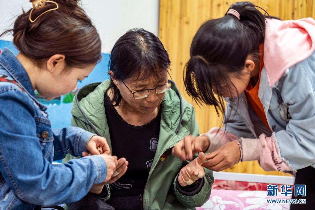每天回到福利院，孩子们都会帮张桂梅撕掉贴了一天的止痛胶带（3月23日摄）。新华社记者 江文耀 摄.jpg